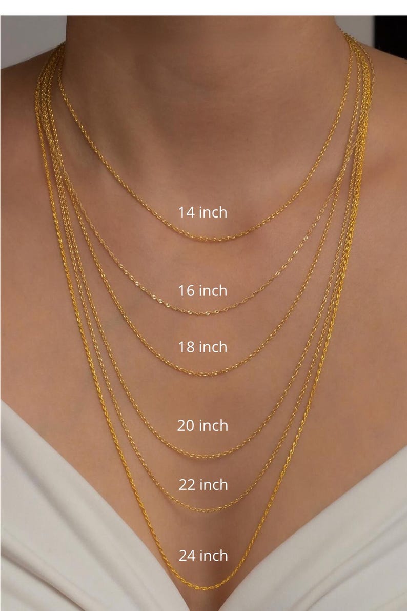 May include: A selection of gold-coloured necklaces of different lengths, shown against a plain backdrop. The necklaces vary from 35.5 cm to 61 cm in length, each clearly labelled. The chains have a delicate, textured design.
