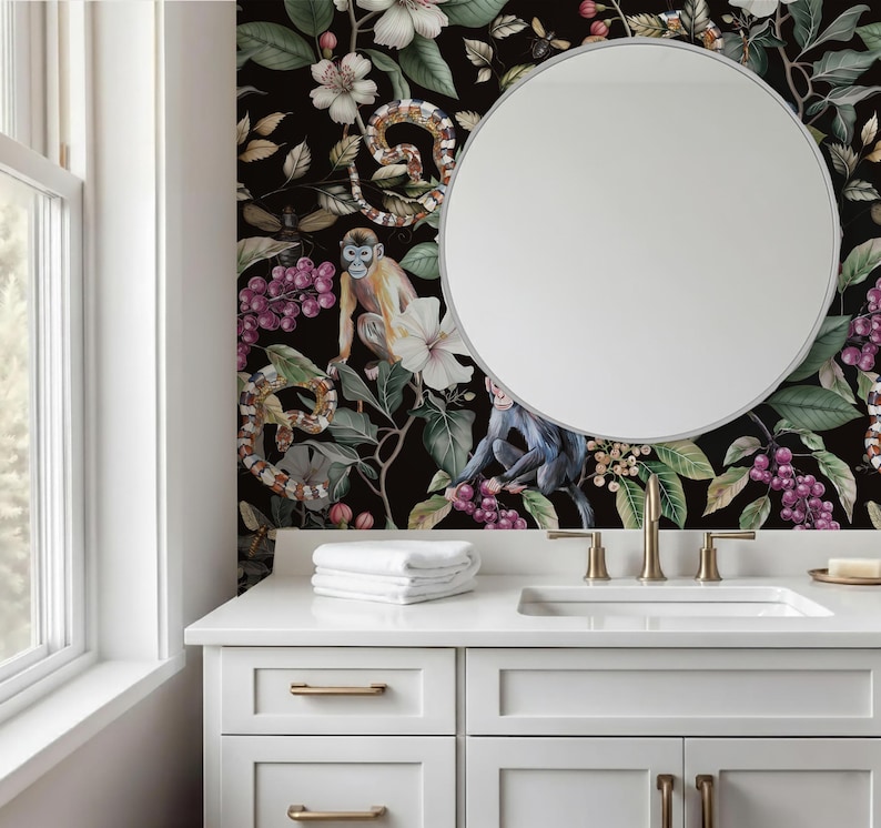 May include: A bathroom vanity with a white countertop, sink, and drawers. A round mirror hangs on a wall with a dark floral and animal print. The print features monkeys, snakes, flowers, and berries. A stack of white towels sits on the counter.