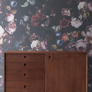 May include: A dark wood cabinet with four drawers and a single door. The cabinet has a dark wood finish and is sitting in front of a wall with a floral wallpaper pattern.