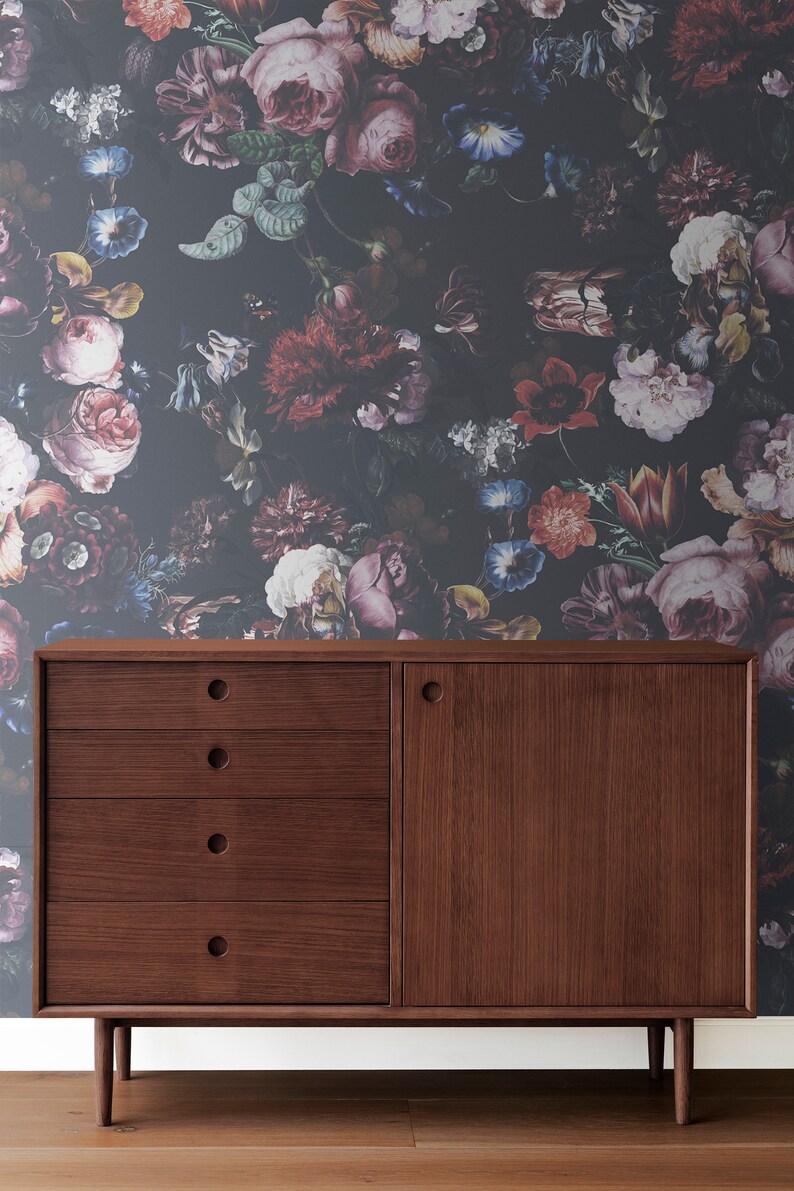May include: A dark wood cabinet with four drawers and a single door. The cabinet has a dark wood finish and is sitting in front of a wall with a floral wallpaper pattern.