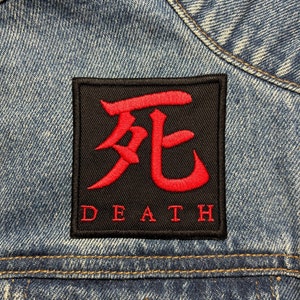 May include: A black and red embroidered patch with the Japanese kanji for "death" and the word "DEATH" written below it.
