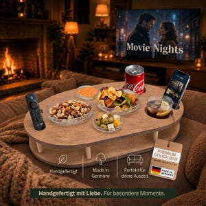 Könnte beinhalten: Ein ovales Couch-Bar-Tablett aus Holz mit Aussparungen für eine Fernbedienung, eine Getränkedose und ein Smartphone. Das Tablett enthält vier Glasschalen mit Nüssen, Chips, Oliven mit Käse und einem Dip. Ein Etikett zeigt den Text Premium Couch Bar.