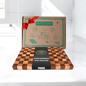 May include: A brown and natural wood chopping board with a chequered pattern. The board is 40 cm by 30 cm by 3 cm. The board has a label that says "Premium Schneidebrett 40 cm x 30 cm x 3cm Pegsen".