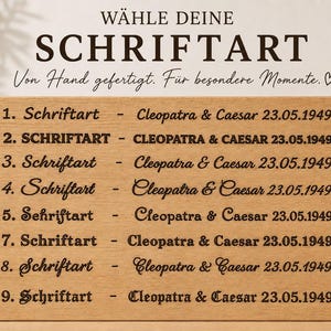 May include: A wooden plaque with engraved text showcasing different font styles. The text includes the words "W&Auml;HLE DEINE SCHRIFTART" and "Von Hand gefertigt. F&uuml;r besondere Momente." Below are numbered font samples with names and dates.