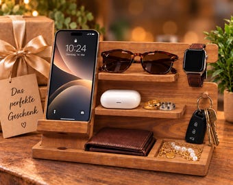 May include: A wooden desk organiser featuring a smartphone stand, two small shelves for sunglasses and white wireless earbuds, a watch holder, a key hook, a wallet compartment, and a small tray for jewellery, all arranged on a rectangular base.