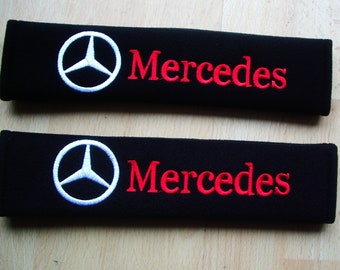 A pair of beautifully embroidered Mercedes soft seat belt covers