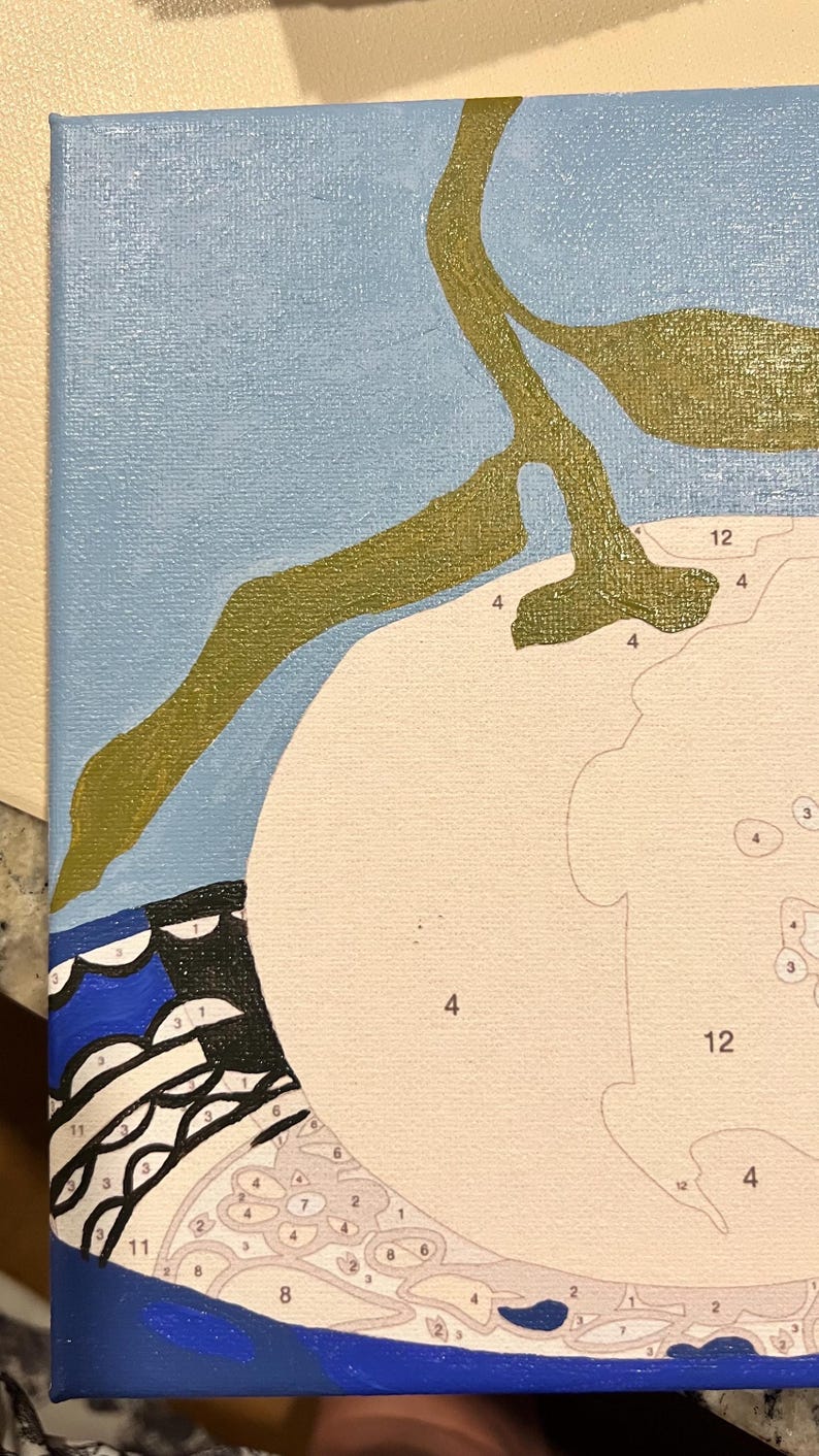 May include: A paint-by-numbers canvas in progress. The image shows a light blue background, a white shape, and olive green branches. The lower left corner has a blue and black patterned design. Numbers are visible within the white shape.