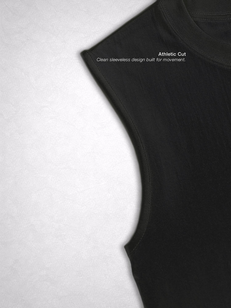 Op de afbeelding: Een close-up van een zwart mouwloos atletisch gesneden shirt. De tekst "Athletic Cut" en "Clean sleeveless design built for movement" is zichtbaar op het shirt.
