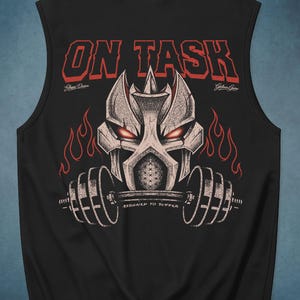 Op de afbeelding: Zwart mouwloos shirt met een grafisch ontwerp van een krijgershelm die een halter vasthoudt. De rode tekst "ON TASK" staat boven de helm, met "ASSIGNED TO SUFFER" eronder. Vlammen en details.