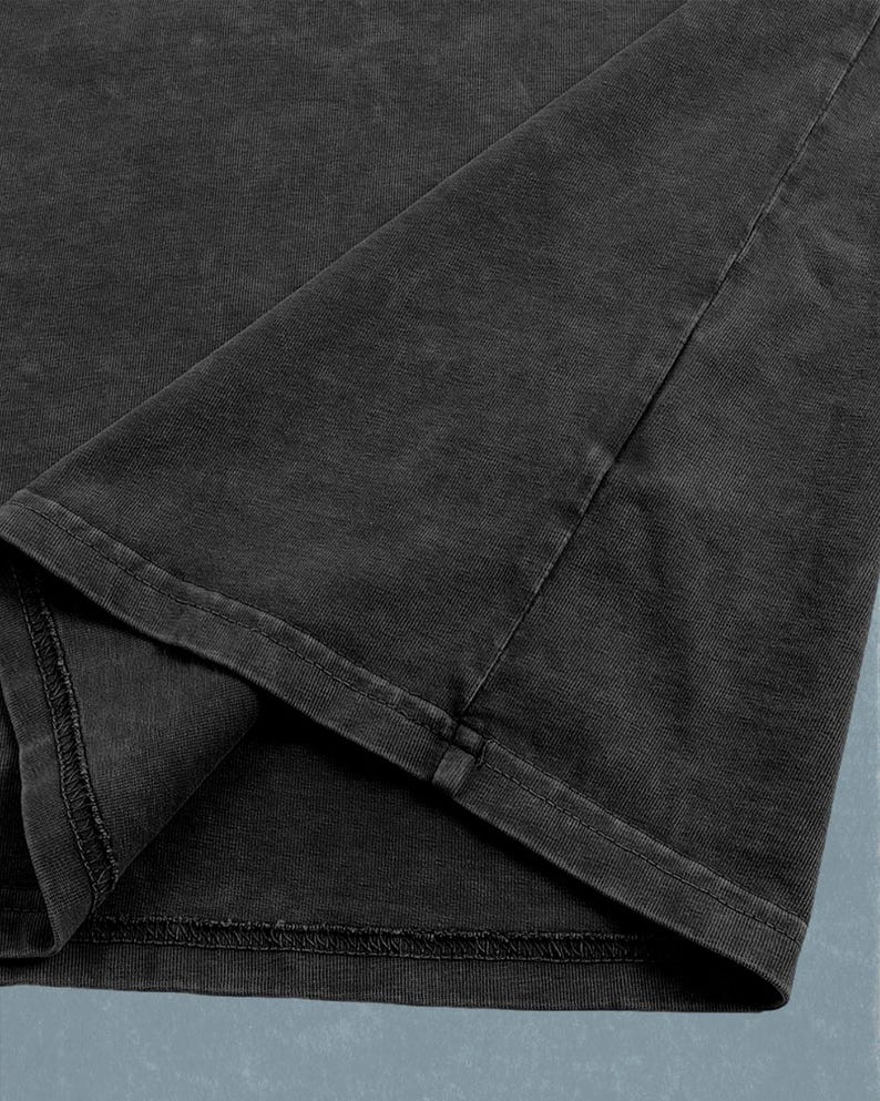 A close-up view of a dark grey fabric, possibly a piece of clothing or a textile.