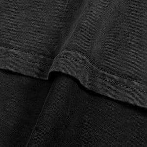 The image is a close-up of a dark grey fabric, possibly a piece of clothing or a textile. The fabric appears to be made of a woven or knitted material, with a textured and slightly wrinkled appearance.