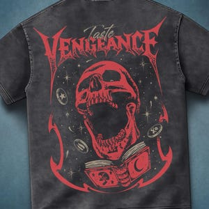 Pode incluir: T-shirt cinza escuro com um gráfico vermelho de uma caveira, um livro aberto e o texto "Taste Vengeance". O design inclui estrelas e elementos semelhantes a moedas. A camisa tem um visual vintage e desgastado.