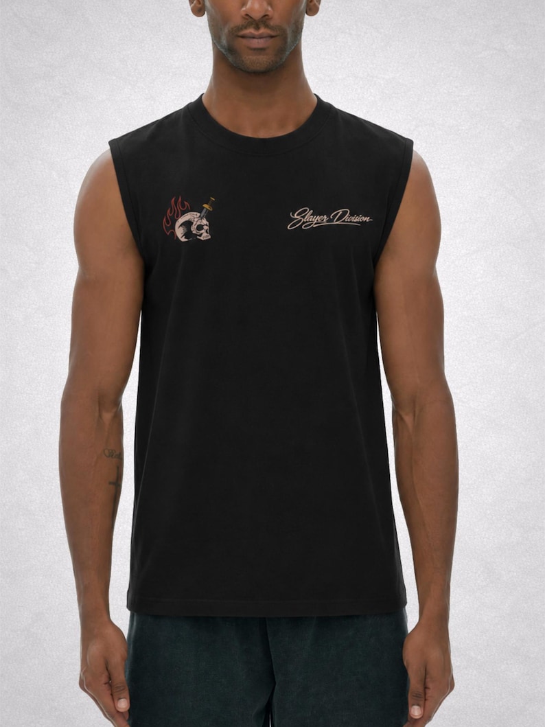 Op de afbeelding: Zwart mouwloos shirt met een schedelafbeelding doorboord door een dolk en de woorden "Slayer Division" in een cursief lettertype. De schedel is omgeven door vlammen. Het shirt is gemaakt van een zacht materiaal.