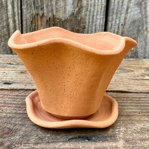 May include: A set of three ceramic mugs with a speckled, matte finish. The mugs are in shades of cream, light brown, and dark brown. Each mug has a simple, minimalist design, perfect for coffee or tea.