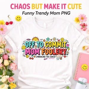May include: White t-shirt with the text "OFF TO COMMIT MOM FOOLERY" in colorful bubble letters, surrounded by flowers, smiley faces, and other playful graphics. The shirt also has the text "EMBRACING THE CHAOS!".