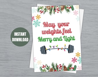May include: A white Christmas card with a green, red, and brown floral border. The card features a barbell with Christmas lights and the text "May your weights feel Merry and Light".