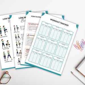 May include: A collection of white exercise trackers and guides with teal accents. The guides feature illustrations of exercises and text, including "LOW IMPACT EXERCISE" and "HOW TO STRU". A spiral notebook, pencil, and paperclips are also visible.