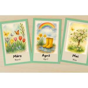 Può includere: Tre biglietti ad acquerello con temi primaverili. I biglietti mostrano i mesi di marzo, aprile e maggio. Il biglietto di marzo mostra fiori e farfalle. Il biglietto di aprile mostra stivali di gomma gialli e un arcobaleno. Il biglietto di maggio mostra un albero in fiore.