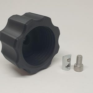 May include: A black plastic knob with a threaded hole in the center. The knob has a star-shaped design with 10 points. Two silver metal fasteners are also included.