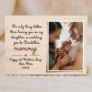 May include: Wooden photo frame with a picture of a baby and two women. The frame has the text "The only thing better than having you as my daughter, is watching you be Charlotte's mommy. Happy 1st Mother's Day! Love, Mom 2025."