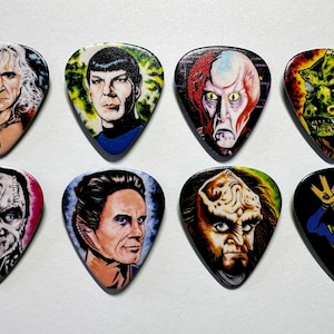 May include: Eight guitar picks featuring characters from the Star Trek franchise. The picks are colourful and feature detailed illustrations of Spock, Kirk, Data, Worf, and other characters.