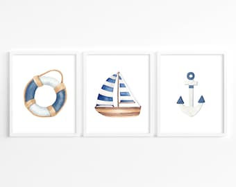 May include: Three framed watercolor illustrations with a nautical theme. The first image shows a blue and white life preserver. The second image shows a blue and white sailboat. The third image shows a blue anchor.