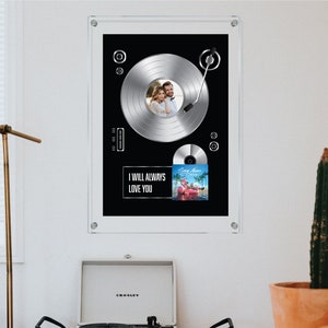 May include: A framed black and silver record player with a photo of a couple in the center of the record. The record is titled "I Will Always Love You".