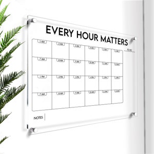 Pode incluir: Um quadro branco de acrílico transparente com uma grade preta e o texto "EVERY HOUR MATTERS" no topo. O quadro tem uma seção para "TO DO" e "NOTES".