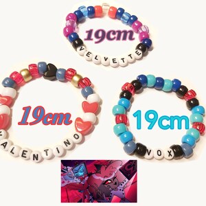 May include: Three beaded bracelets, each approximately 19cm in circumference, with colourful beads and names spelled out in letter beads. One bracelet says "VELVETTE", another "VALENTINO", and the third "VOX". A small image of cartoon characters is in the bottom corner.