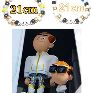 May include: Two cartoon characters, one tall and one short, both wearing white jackets and sunglasses. The taller character has a serious expression, while the shorter character has a more mischievous look. The taller character is wearing sparkly pants. The text "21cm" appears twice in the image, above two beaded bracelets with the names "DALE" and "DEV" spelled out.