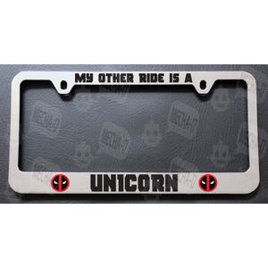 May include: A silver metal license plate frame with the text "My other ride is a unicorn" and two red and black Deadpool logos on either side.