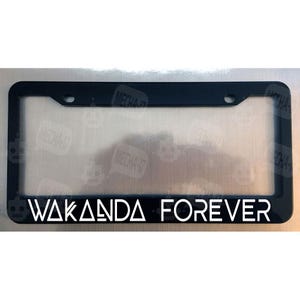 May include: Black license plate frame with white text that reads "Wakanda Forever".