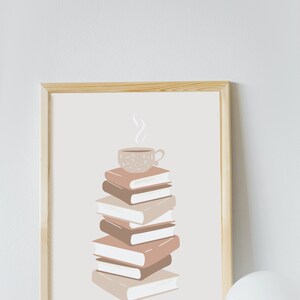 May include: A framed print of a stack of books with a cup of coffee on top. The books are in shades of brown and beige, and the coffee cup is white with brown speckles. The background is a light beige.