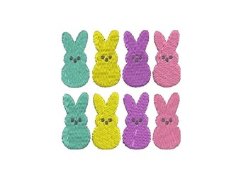 Peut inclure: Huit formes de lapin brodées dans des couleurs pastel : jaune, rose, violet et bleu. Les lapins sont disposés en deux rangées de quatre.