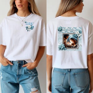 May include: White t-shirt with a floral design and the text "For unto you is born this day" on the front. The back features an image of a nativity scene with the text "A Baby Changes Everything!" surrounded by blue flowers.