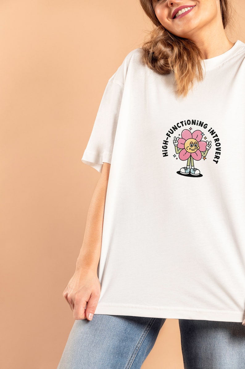 May include: White t-shirt with a pink flower graphic and the text "High-Functioning Introvert".