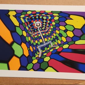 Puede incluir: Una colorida impresi&oacute;n art&iacute;stica que presenta una figura de palo con una cara sonriente en un t&uacute;nel geom&eacute;trico. El t&uacute;nel est&aacute; compuesto por hex&aacute;gonos de varios colores, incluyendo azul, verde, amarillo y morado. El fondo tiene tonos naranja y rojo.