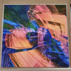May include: Abstract art print featuring layered geometric shapes in shades of orange, pink, and blue. The artwork has a digital, crystalline appearance with a sense of depth and movement. The background has a flowing, watercolor-like effect.