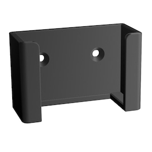 May include: Black plastic wall mount with two holes for screws. The mount has a rectangular shape with a lip on the top and bottom for holding an object.