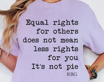 May include: An orchid-colored short-sleeve t-shirt featuring black text that reads: Equal rights for others does not mean less rights for you. It's not pie. RBG. The shirt has a crew neckline and a relaxed fit, showcasing a bold graphic design.