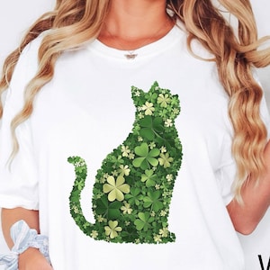 May include: White t-shirt with a green shamrock cat graphic. The cat is made up of shamrocks and is sitting on its haunches.