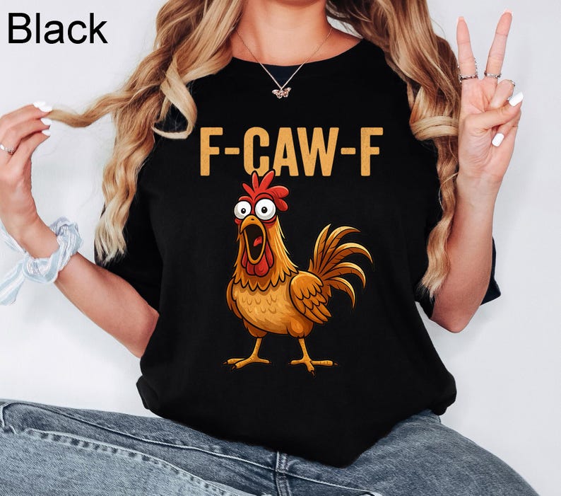 May include: Black t-shirt with the text "F-CAW-F" in gold letters above a cartoon rooster illustration. The rooster is brown, orange, and red with an open beak. The word "Black" is in the upper left corner.