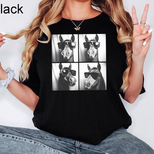 May include: Black t-shirt with a graphic of four horses wearing sunglasses. The horses are arranged in a grid pattern.