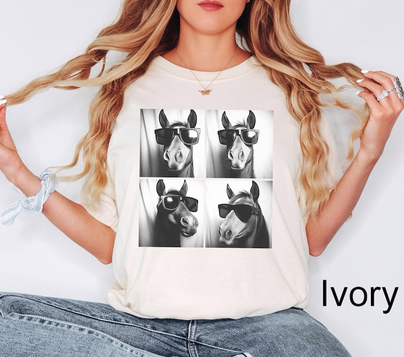 May include: A white t-shirt with a black and white image of four horses wearing sunglasses. The horses are arranged in a grid pattern. The text "Ivory" is visible in the bottom right corner of the image.