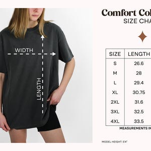 Pu&ograve; includere: Una t-shirt grigio scuro a maniche corte con una tabella delle taglie intitolata Comfort Colors 1717. La tabella elenca le taglie dalla S alla 4XL con le misure di lunghezza e larghezza in pollici. Un diagramma sulla t-shirt indica come misurare.