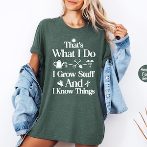 May include: Heather forest green t-shirt with the text "That's What I Do, I Grow Stuff And I Know Things" in white. The shirt features gardening-related icons. The shirt is a casual, comfortable style.