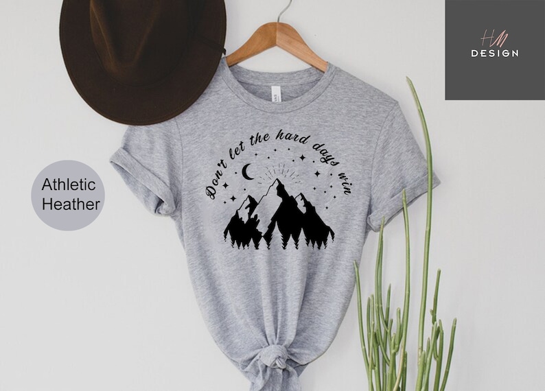 May include: Gray t-shirt with a black mountain range graphic and the text "Don't let the hard days win".