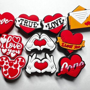 May include: A set of ten red, white, and yellow heart-shaped shoe charms with various love-themed designs, including "I love you", "True Love", and "Love".