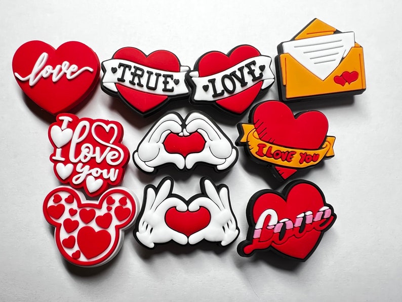 May include: A set of ten red, white, and yellow heart-shaped shoe charms with various love-themed designs, including "I love you", "True Love", and "Love".