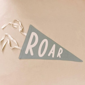 May include: A light green pennant with white rope ties and the word "ROAR" printed in white.